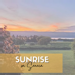 sunrise on seneca text overlaid on a photo of an orange sunrise over a lake with green landscape