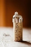 Wedding rings, both bride and groom's, placed a top a Glenora Wine Cellars wine cork.